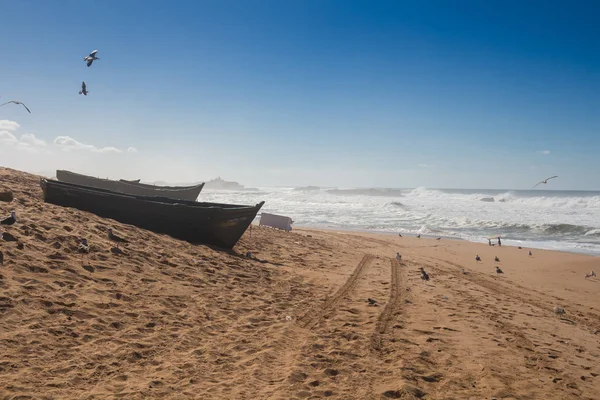 Atlantic ocean beach with boats and seagulls