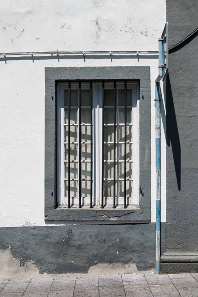Casa con facciata bianca e finestra con grill — Foto Stock