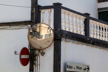 Teraslı beyaz geleneksel bir binaya sahip sokakların köşesi. Kavşak ve giriş yok trafik işareti yansıtan trafik aynası. Ribeira Grande, Sao Miguel, Azores Adaları, Portekiz.