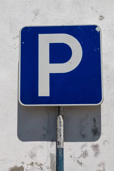 Segnale stradale parcheggio e un vecchio muro bianco — Foto Stock