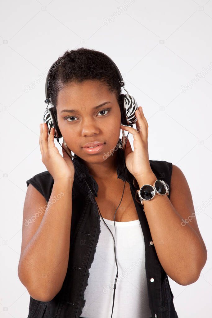 Pretty Black woman listening through ear phones.