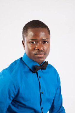 Mavi gömlekli ve papyonlu düşünceli siyah adam.