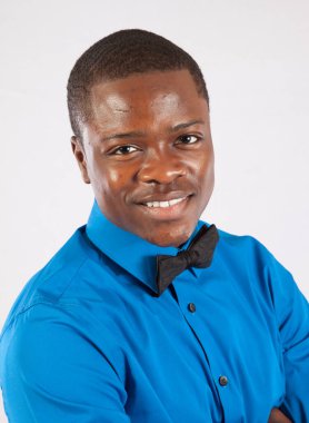 Mavi gömlekli ve papyonlu mutlu siyah adam.