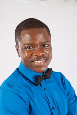 Mavi gömlekli ve papyonlu mutlu siyah adam.