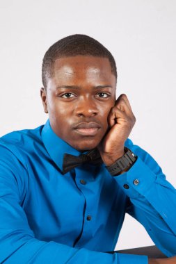 Mavi gömlekli ve papyonlu dalgın siyah adam.