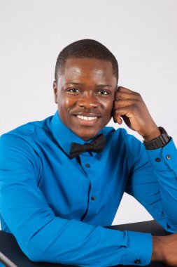 Mavi gömlekli ve papyonlu mutlu siyah adam.