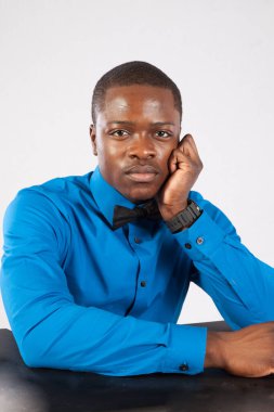 Mavi gömlekli ve papyonlu dalgın siyah adam.