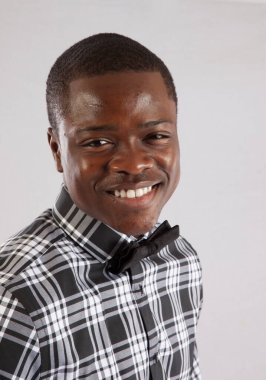 Ekose gömlekli ve papyonlu mutlu siyah adam.