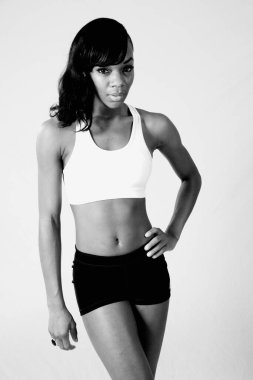 Eli kalçasında düşünceli siyah bir kadın.