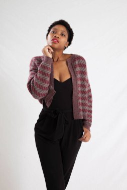 Güzel siyah kadın siyah bir elbise ve ceket içinde dalgın görünüyor.