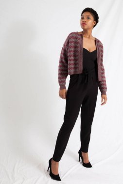 Güzel siyah kadın siyah bir elbise ve ceket içinde dalgın görünüyor.