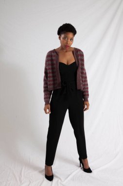 Güzel siyah kadın siyah bir elbise ve ceket içinde dalgın görünüyor.