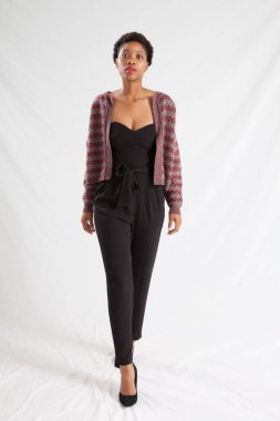 Güzel siyah kadın siyah bir elbise ve ceket içinde dalgın görünüyor.