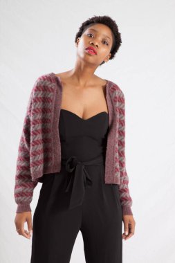 Güzel siyah kadın siyah bir elbise ve ceket içinde dalgın görünüyor.