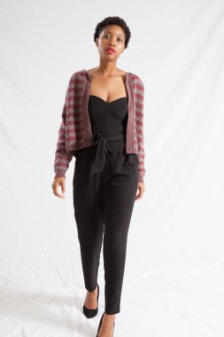 Güzel siyah kadın siyah bir elbise ve ceket içinde dalgın görünüyor.