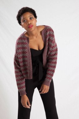 Güzel siyah kadın siyah bir elbise ve ceket içinde dalgın görünüyor.