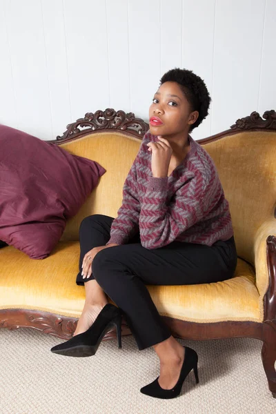 漂亮的黑人女人坐在金床上 — 图库照片