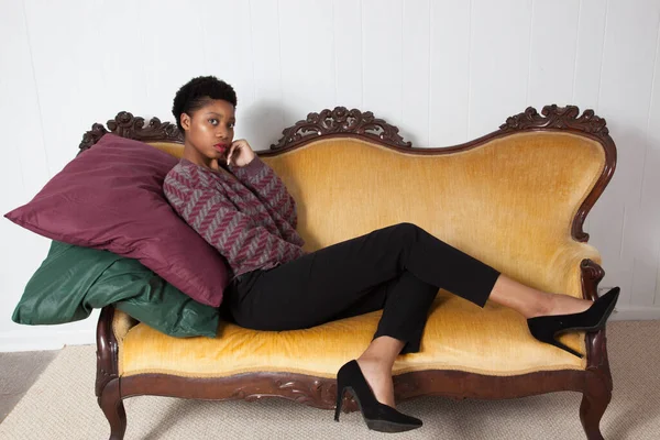 漂亮的黑人女人坐在金床上 — 图库照片