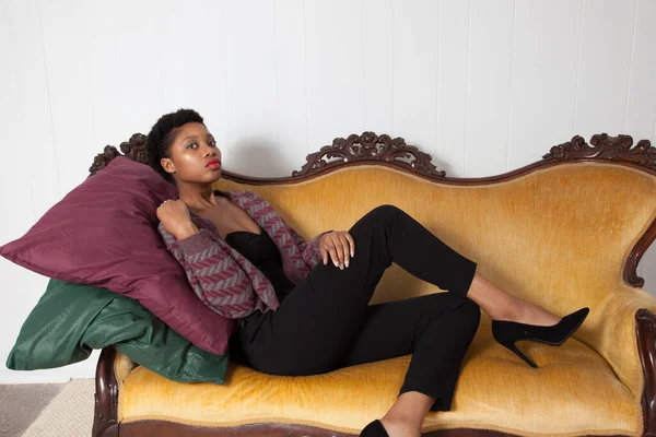 漂亮的黑人女人坐在黄金沙发上 — 图库照片