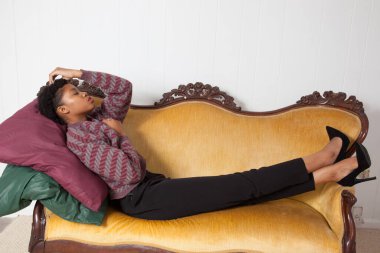 Güzel siyah kadın altın bir koltukta oturuyor.