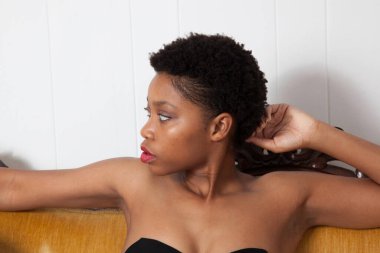 Altın koltukta oturan dalgın siyah kadın.