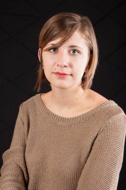 Kahverengi kazaklı, düşünceli bir kadın.