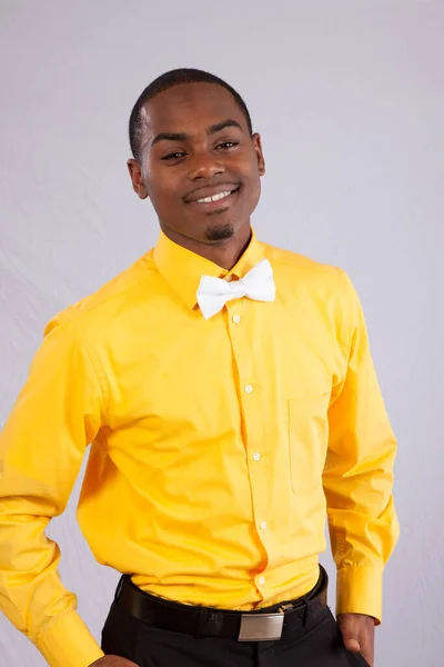 幸せな黒男で黄色のシャツと白の蝶ネクタイ — ストック写真