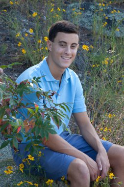 Yakışıklı adam dışarıda oturuyor ve rahatlıyor.