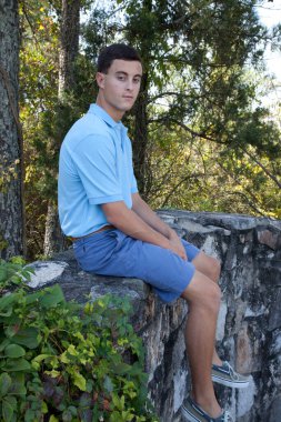 Dışarıda oturan ve rahatlayan sevimli bir adam.