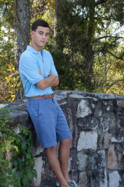 Kolları bağlı dalgın bir adam.