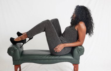 Güzel siyah kadın düşünceli bir şekilde oturuyor.