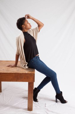 Tahta masada oturan düşünceli kadın.