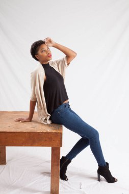 Tahta masada oturan düşünceli kadın.