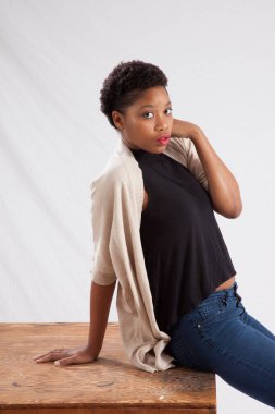 Tahta masada oturan düşünceli kadın.