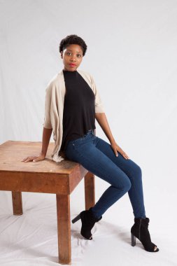 Tahta masada oturan düşünceli kadın.