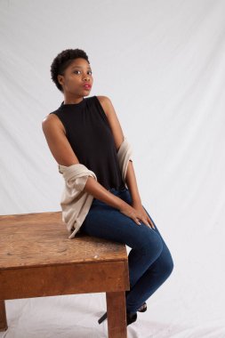 Tahta masada oturan düşünceli kadın.