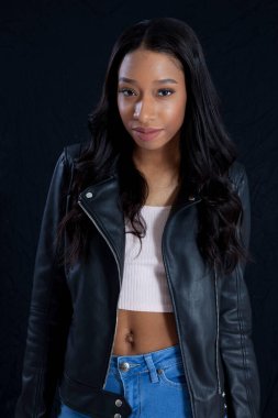 Siyah deri ceketli, gülümseyen güzel bir kadın.