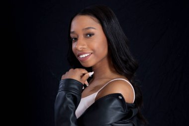 Siyah deri ceketli, gülümseyen güzel bir kadın.