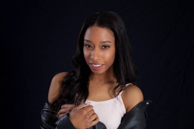 Siyah deri ceketli, gülümseyen güzel bir kadın.