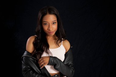 Siyah deri ceketli, gülümseyen güzel bir kadın.