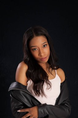 Siyah deri ceketli, gülümseyen güzel bir kadın.