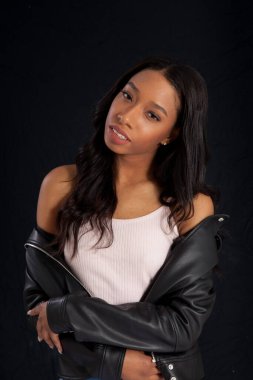 Siyah deri ceketli hoş bir kadın, düşünceli görünüyor.