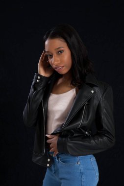 Siyah deri ceketli hoş bir kadın, düşünceli görünüyor.