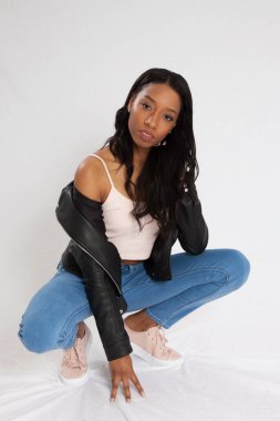 Kot pantolonla çömelmiş dalgın siyah kadın