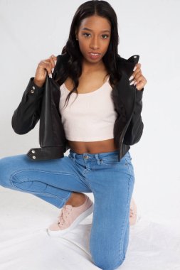 Kot pantolonla çömelmiş dalgın siyah kadın