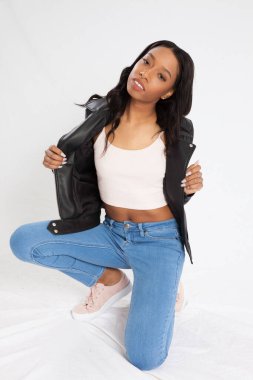 Kot pantolonla çömelmiş dalgın siyah kadın