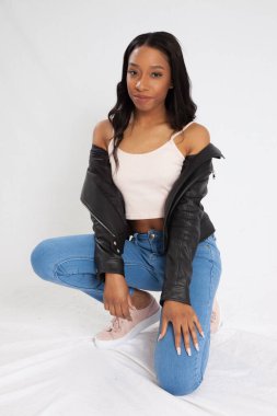 Kot pantolonla çömelmiş dalgın siyah kadın