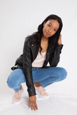 Kot pantolonla çömelmiş dalgın siyah kadın