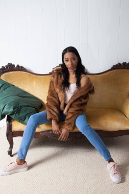 Kürklü güzel kadın, kanepede dinleniyor.