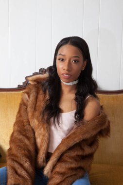 Kürklü güzel kadın, kanepede dinleniyor.